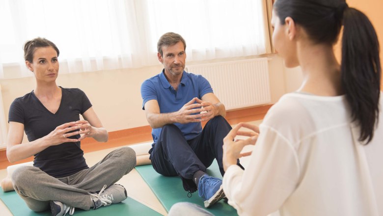Entspannungstraining, © Xundheitswelt Drei Personen sitzen auf Yogamatten und machen Entspannungsübungen.