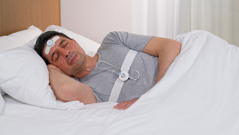 Somfit pro patient Compumedics Ltd., © Klinik Pirawarth Mann schläft mit Schlafüberwachungsgerät im Bett.