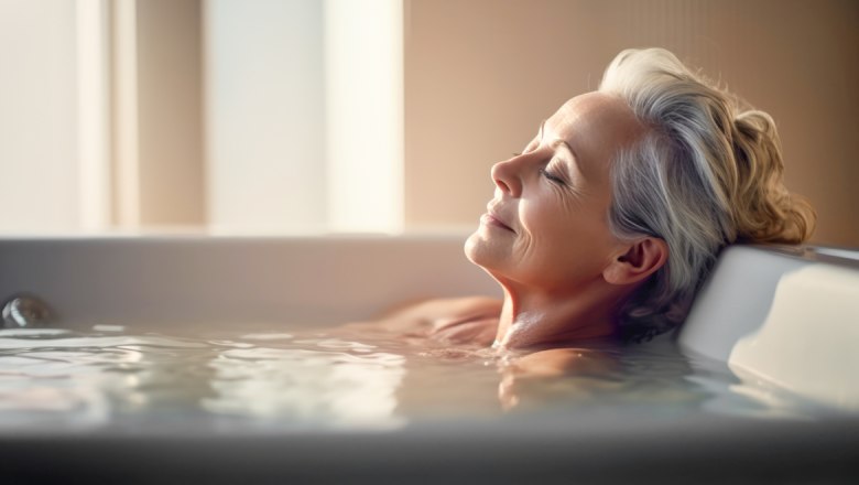 Angebot SchwefelPLUS, © Adobe Stock Eine ältere Frau entspannt sich in einer Badewanne mit geschlossenen Augen und einem zufriedenen Lächeln.