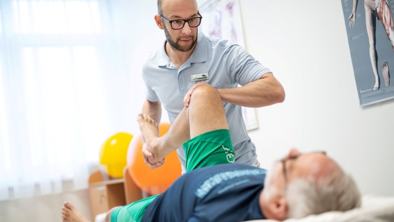 Physiotherapie, © Moorheilbad Harbach Ein Physiotherapeut behandelt das Bein eines liegenden Patienten in einem Behandlungsraum.