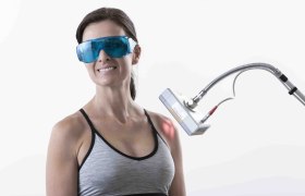 Frau mit Schutzbrille und Lasergerät.