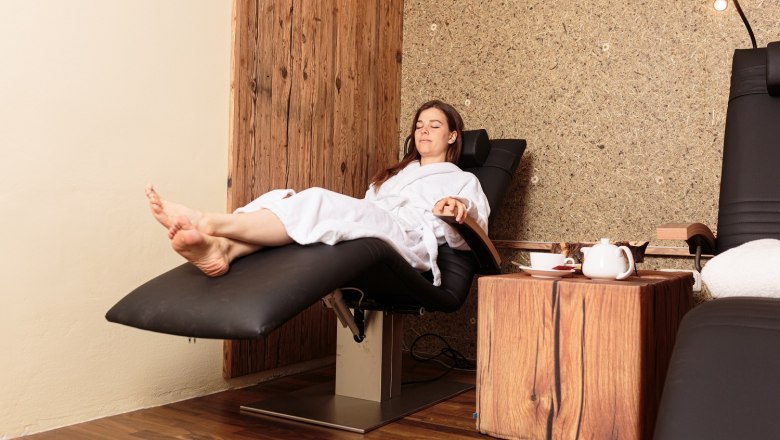 Frau entspannt auf einer Wärmeliege in einem Wellnessbereich.
